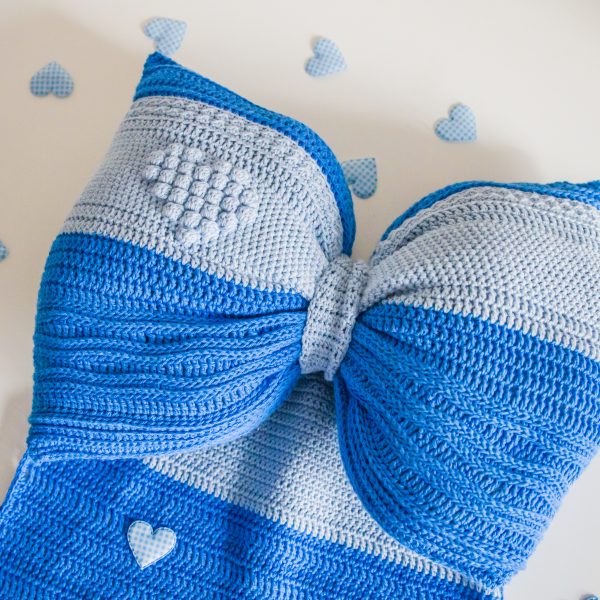 dark and light blue crochet bow with tiny hearts around it